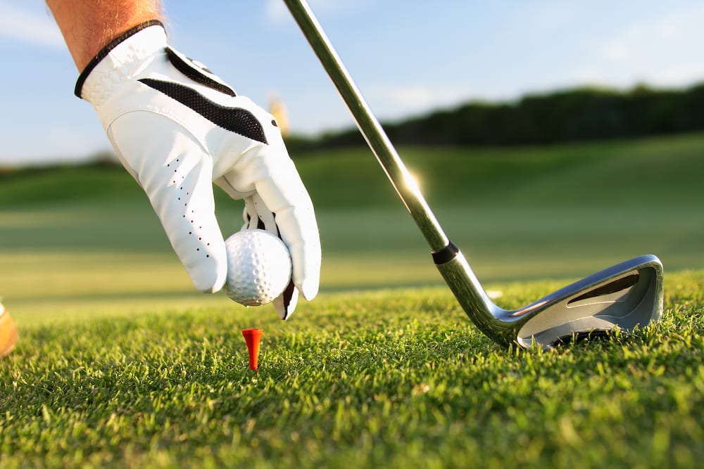 Golfer teeing up a golf ball