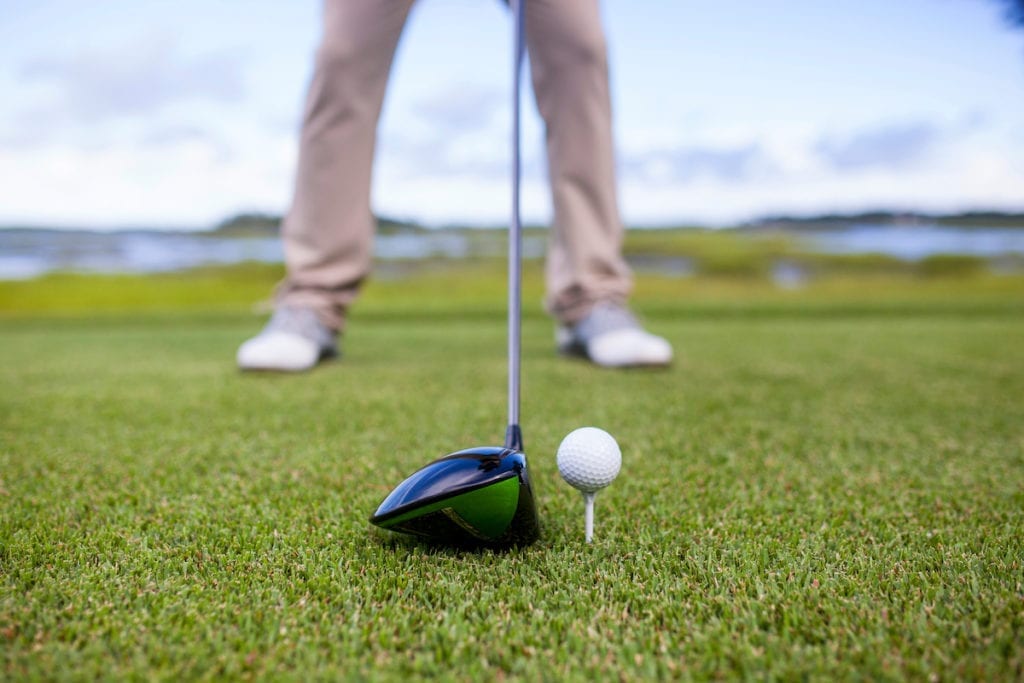 Golfer standing with the proper stance ready to hit the ball