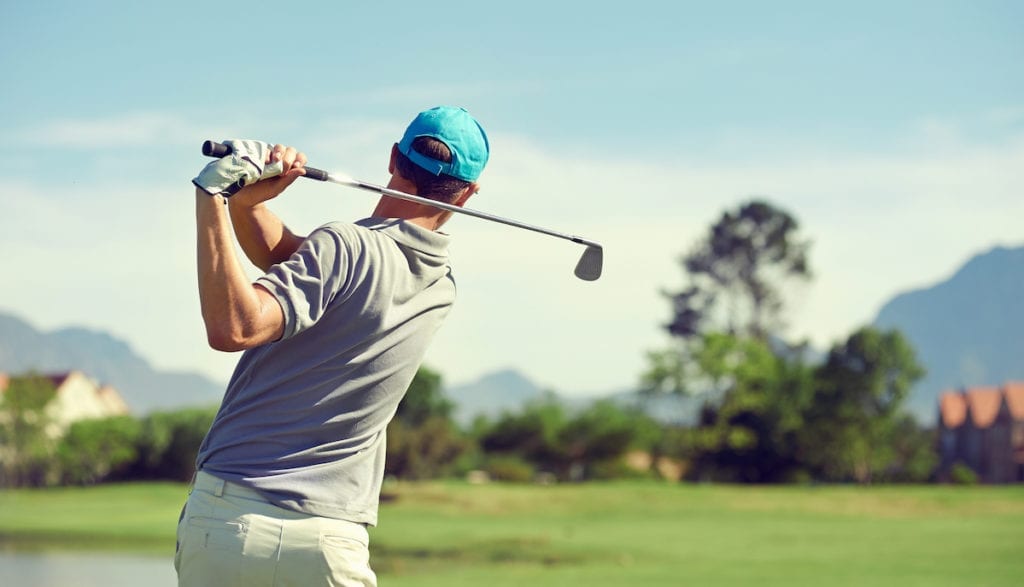 Golfer standing with the proper stance ready to hit the ball