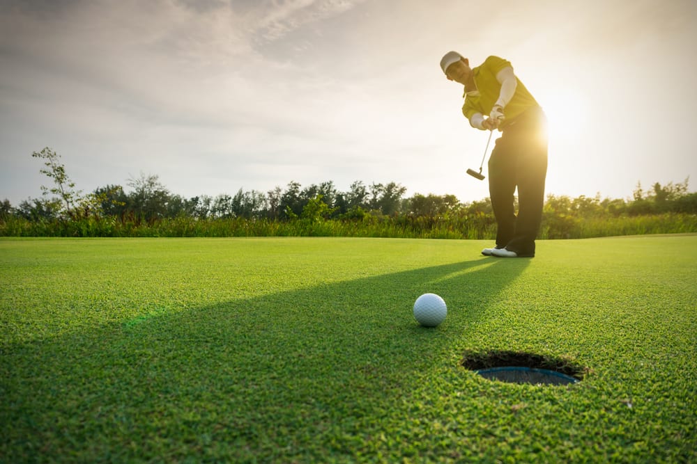 Golfer putting on the green