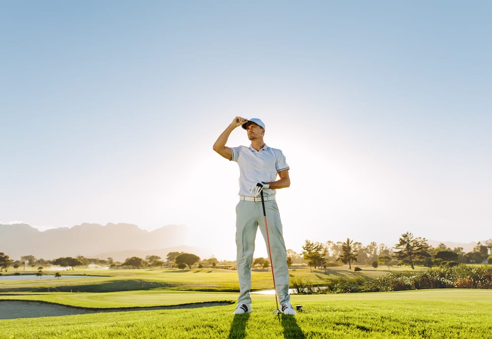 Golfer standing on course