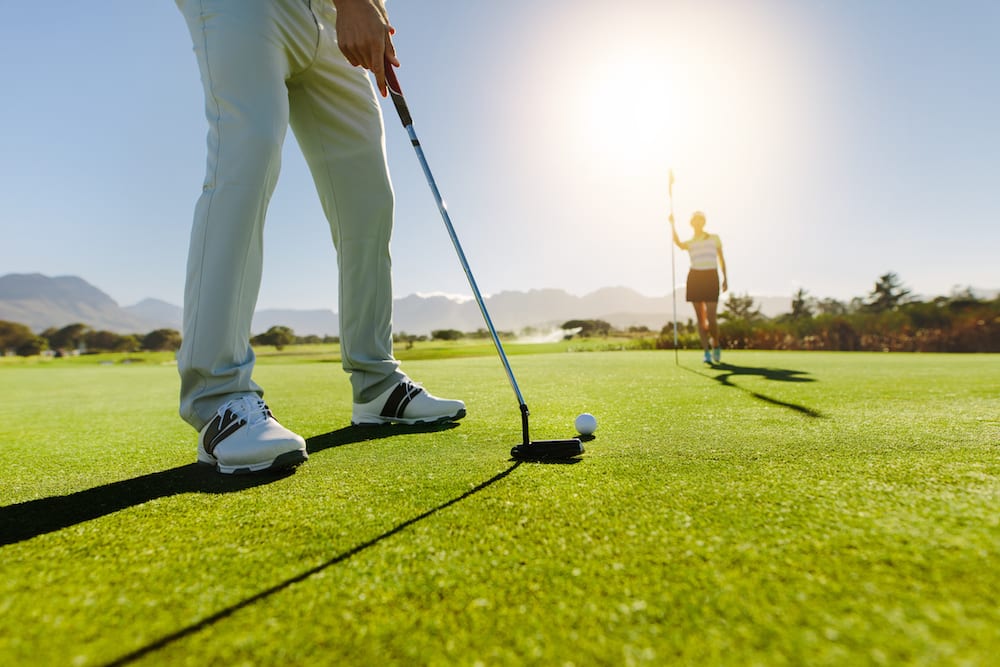 Golfers putting on green